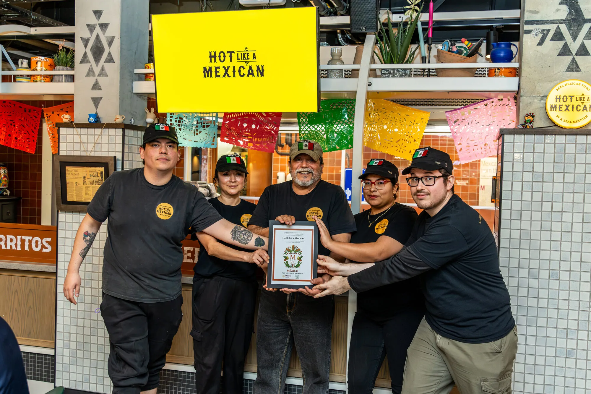 The Hot Like a Mexican kitchen team hold the Sello M certificate together